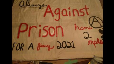 Banner with hand-written words in black and red: Always Against Prison Ⓐ Hami to MPLS for a fiery 2021